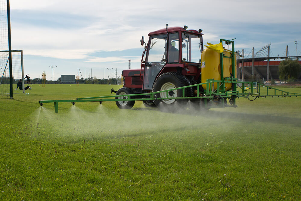 Greenkeeper düngt das Fußballfeld 